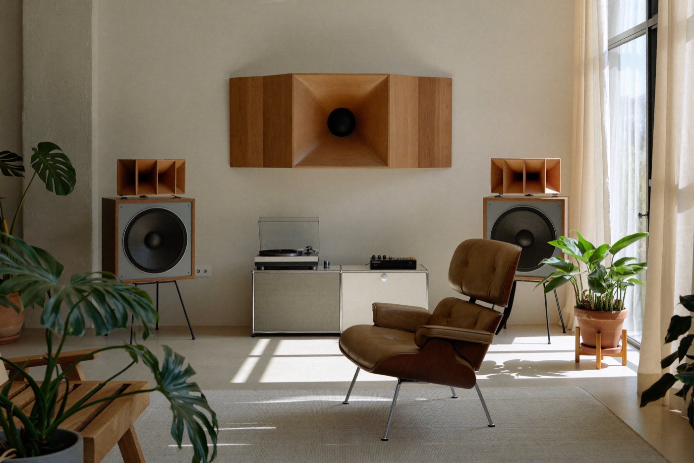 Sala d'ascolto con poltrona in pelle tra due diffusori e console con giradischi